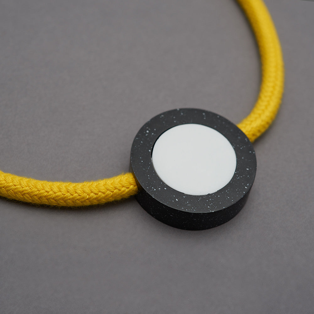 Ab necklace is a bright and striking necklace with movable resin parts. Bright yellow rope. Full drop 40cm, fully adjustable using a black ball which sits behind the neck. Black speckled resin circle 40mm diameter x 10mm White resin circle which sits inside, 30mm x 10mm Black resin rectangle 30mm x 10mm