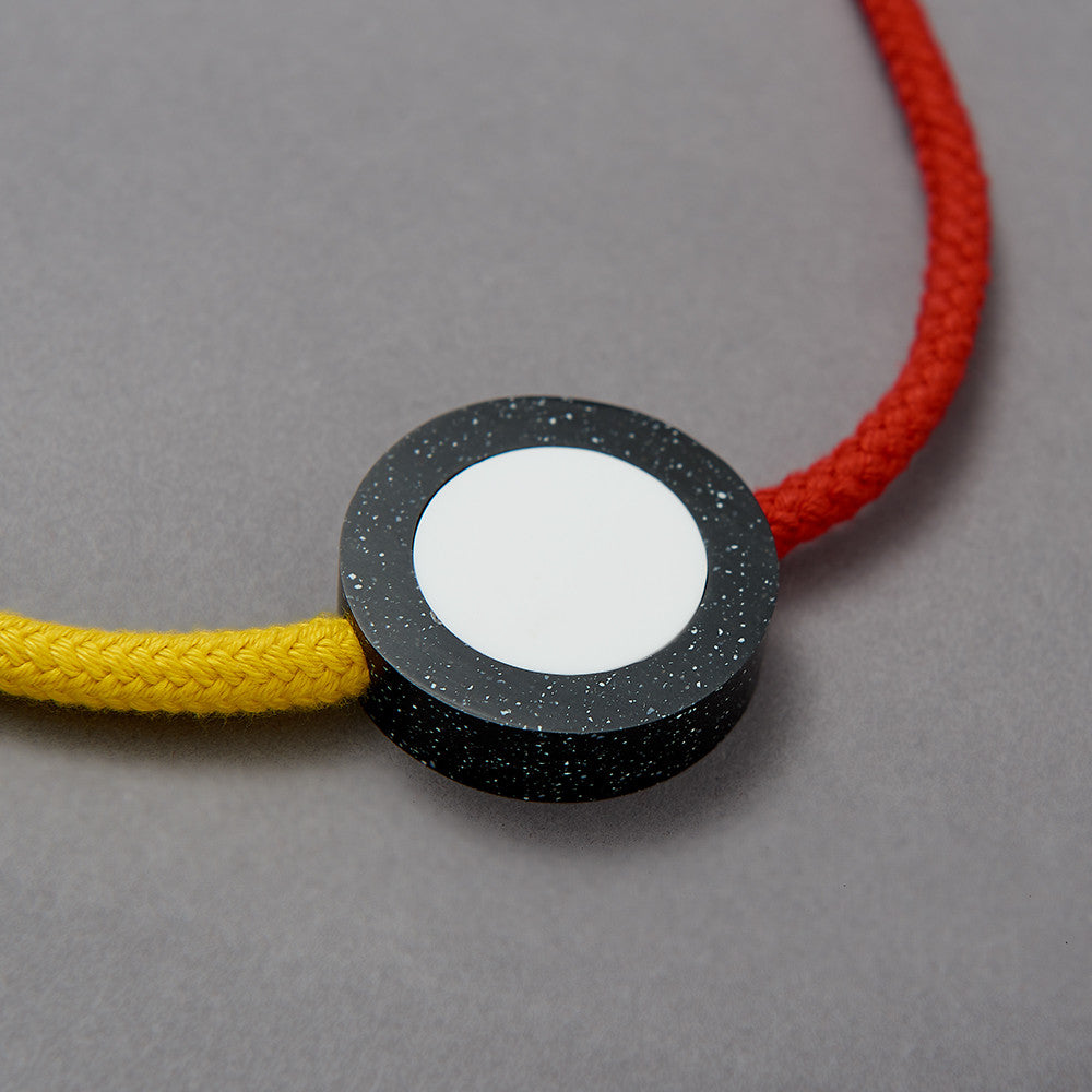 The Beck necklace is a Bright and striking statement necklace inspired by the London Underground Tube Map. Bright yellow and red rope work in combination with resin parts. Full drop 40cm, fully adjustable using a black ball which sits behind the neck. 