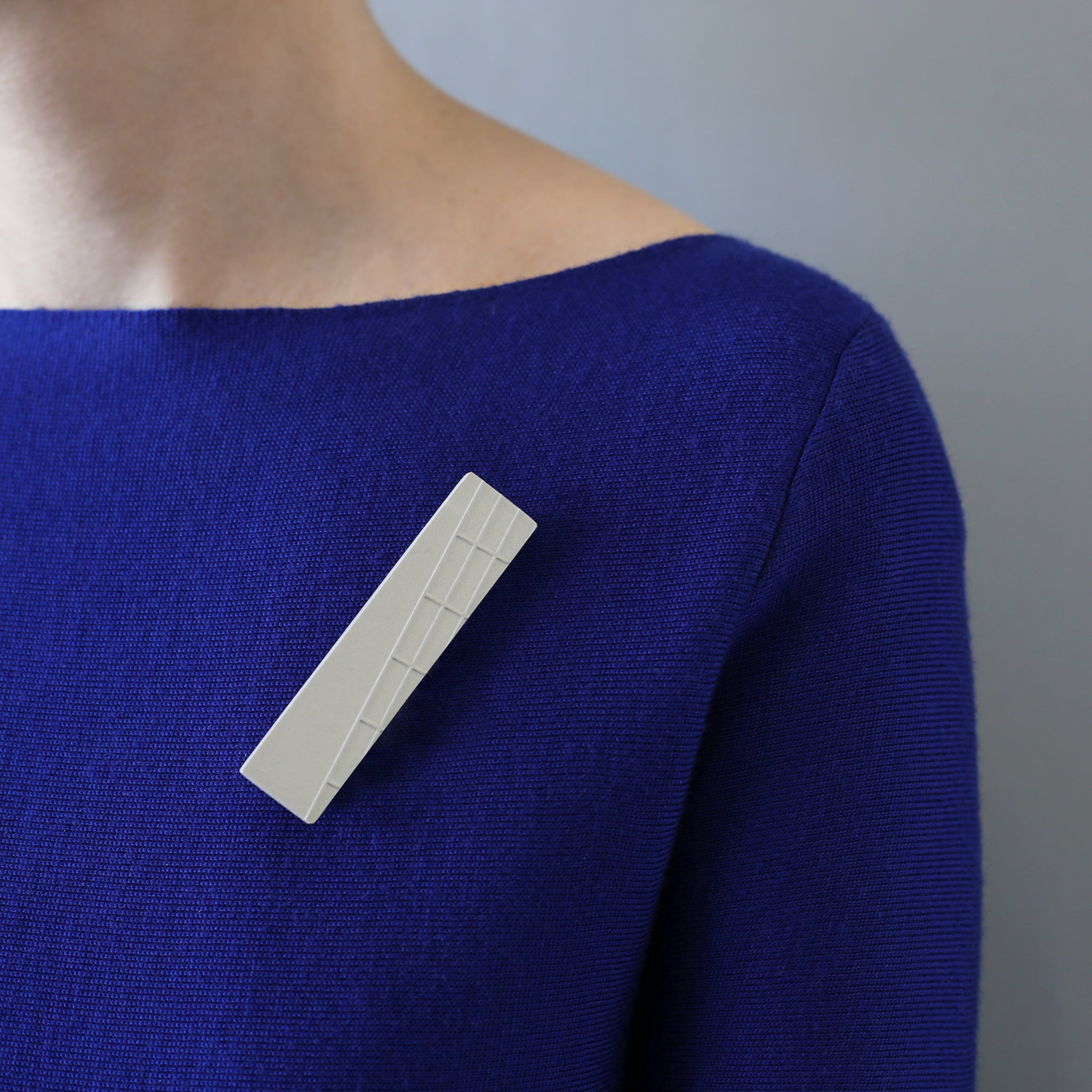 Handcast brooch inspired by the brutalist architecture of London's Barbican centre. This rectangular brooch has a raised grid pattern on part of the surface. Each brooch is cast by hand in our south London studio and comes in branded gift box. Dimensions: 8cm x 2cm