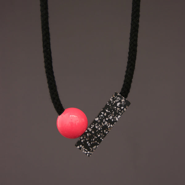 The Ad necklace is a minimalist and stylish design. It is composed of 2 main parts - A section of black corian with fine speckles of grey and white (60mm x 18mm) and a coloured ball (25mm).