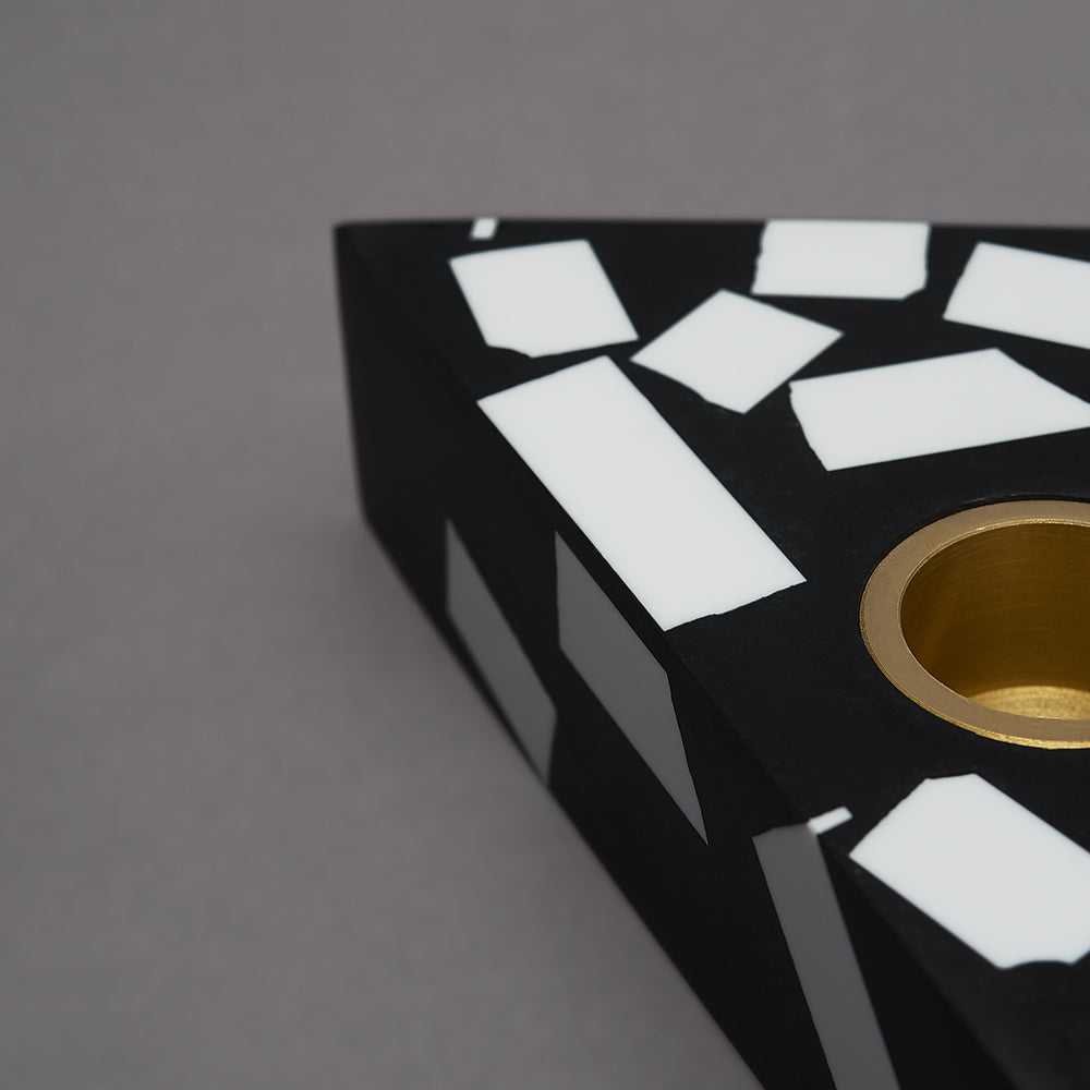 Each candle holder is hand made from black Jesmonite with graphic white chips. It has a fixed brass insert. Designs come packaged within a branded box. Subtle variations of white chip arrangement makes each piece unique. Product dimensions: 11cm x 11cm x 3cm Candle not included.