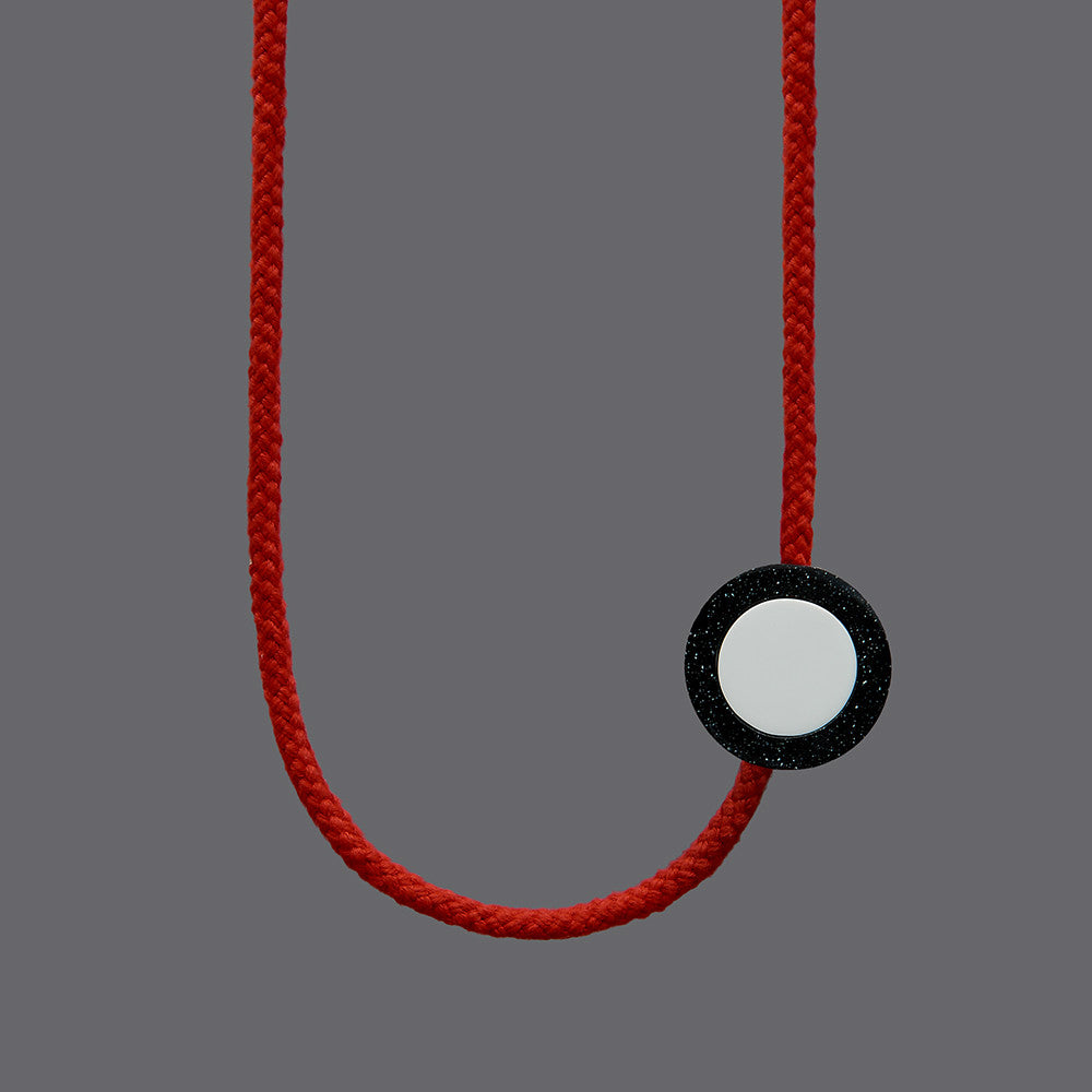 The Ed necklace is part of the collection we launched with Transport For London at Clerkenwell Design Week 2017.Bright and striking necklace. Bright red rope. Small yellow balls on the end of each rope. (15mm)Black speckled resin circle 40mm diameter x 10mm White resin circle which sits inside, 30mm x 10mm