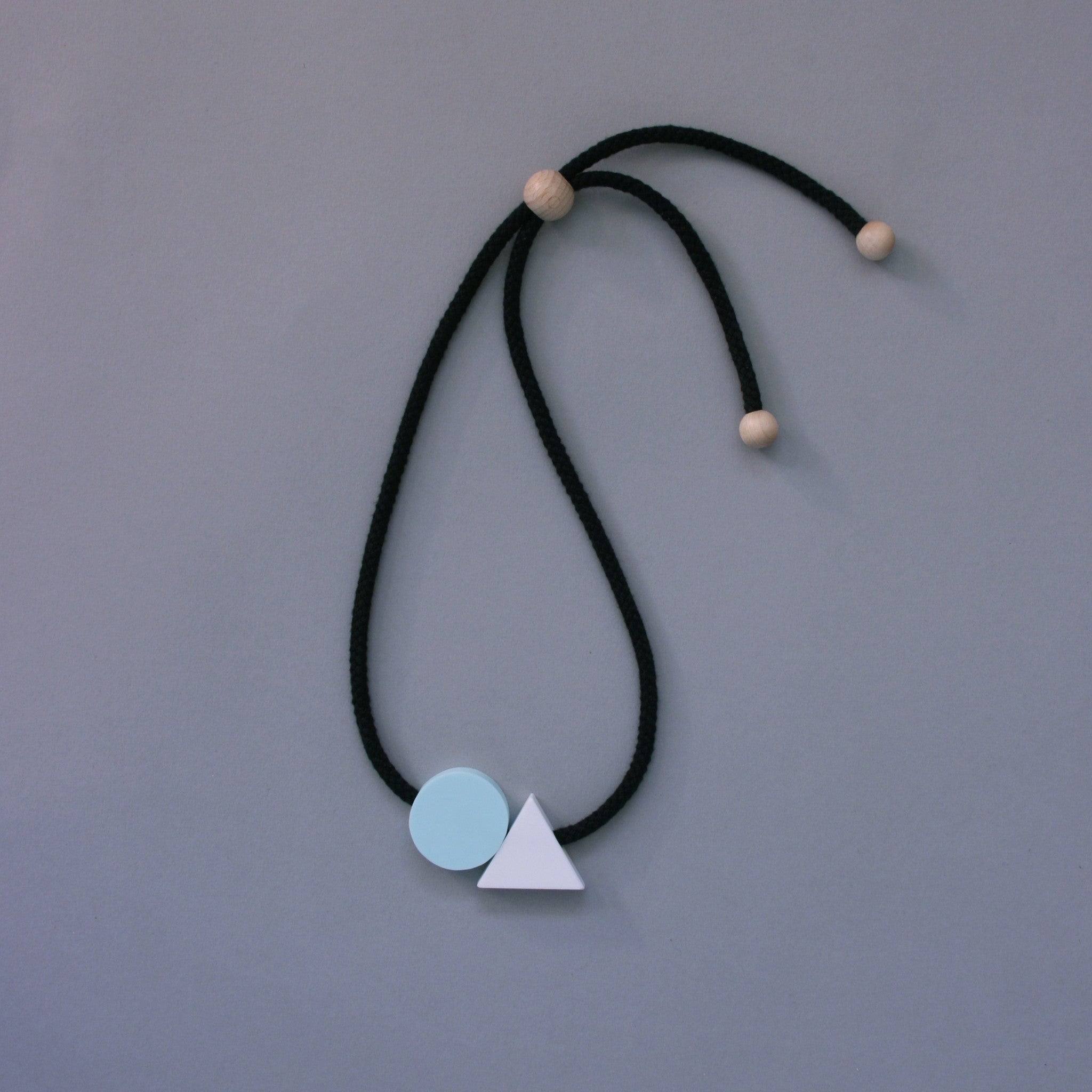 The Ellsworth necklace is a pleasing balance of 2 geometric shapes. A mint circle sits neatly beside a white triangle offering a striking and minimal addition to any outfit. A geometric statement necklace.