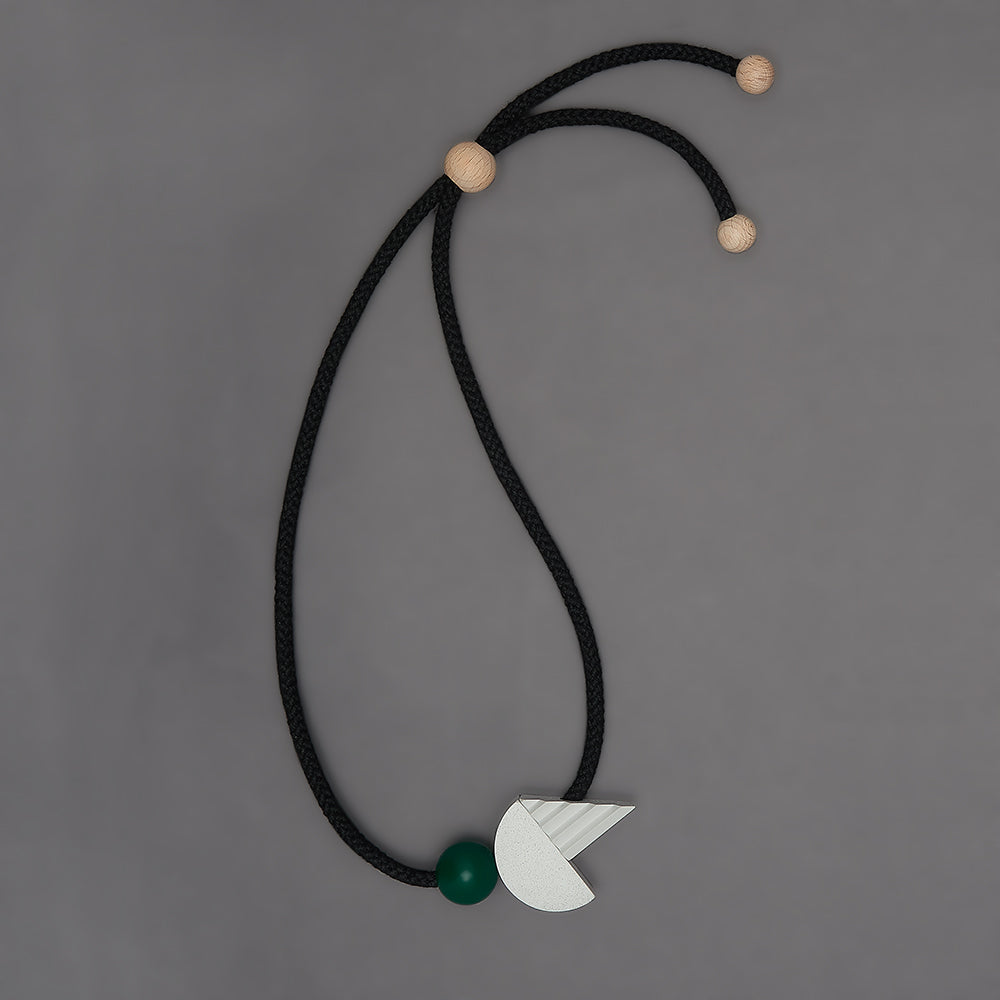 The pop necklace is composed of 2 handcast shapes. A lovely concrete-effect curve measuring 50mm x 25mm which sits beside a cast ridged triangle which measures 30mm x 45mm. The bright green ball (25mm) offers a pop of colour beside the understated concrete resin shapes.