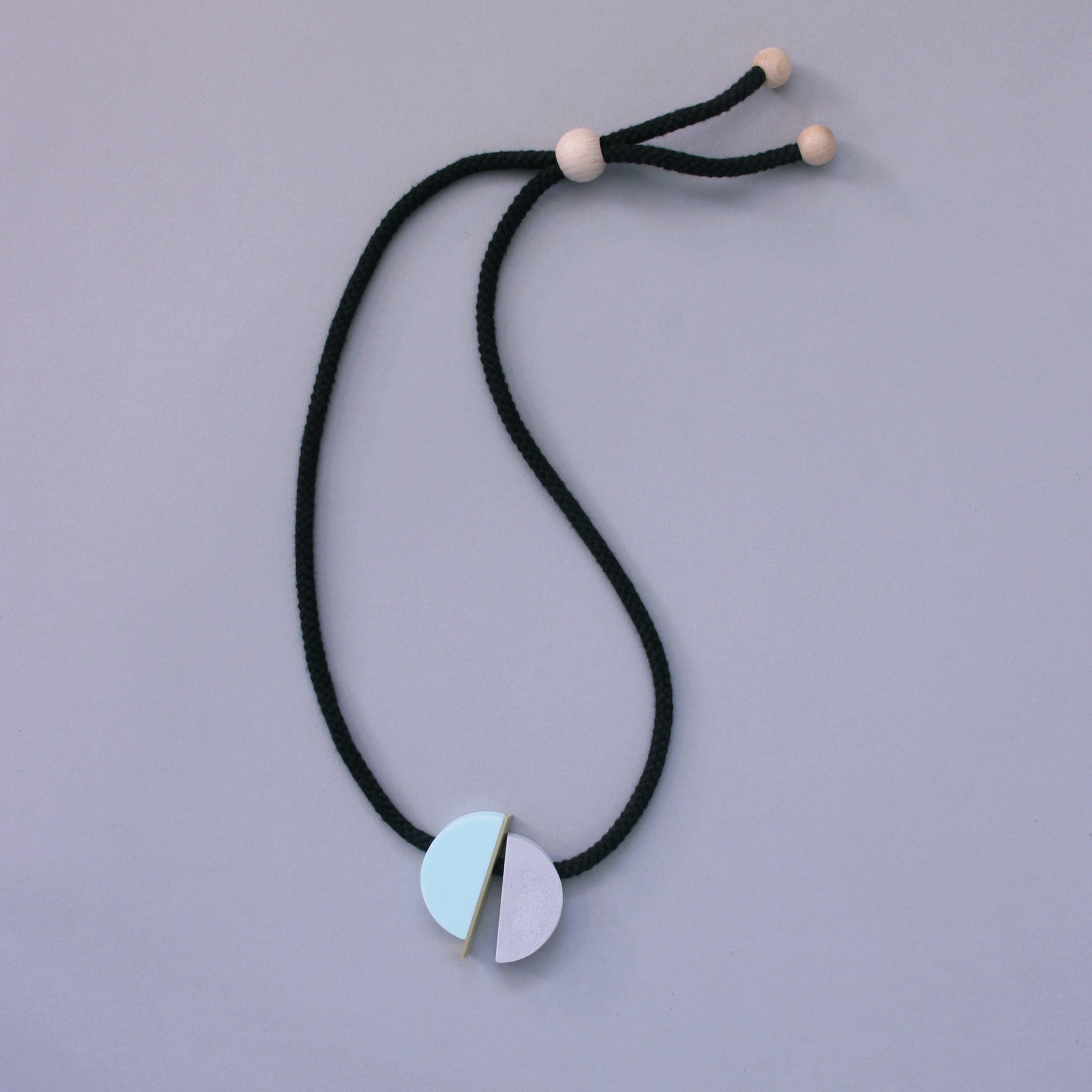 The Klee necklace is both elegant and fun. The three sections can move freely allowing the design to fall in different ways.  Klee is composed of our hand cast concrete-resin, a brass strip and a mint resin curve. A playful, contemporary design.