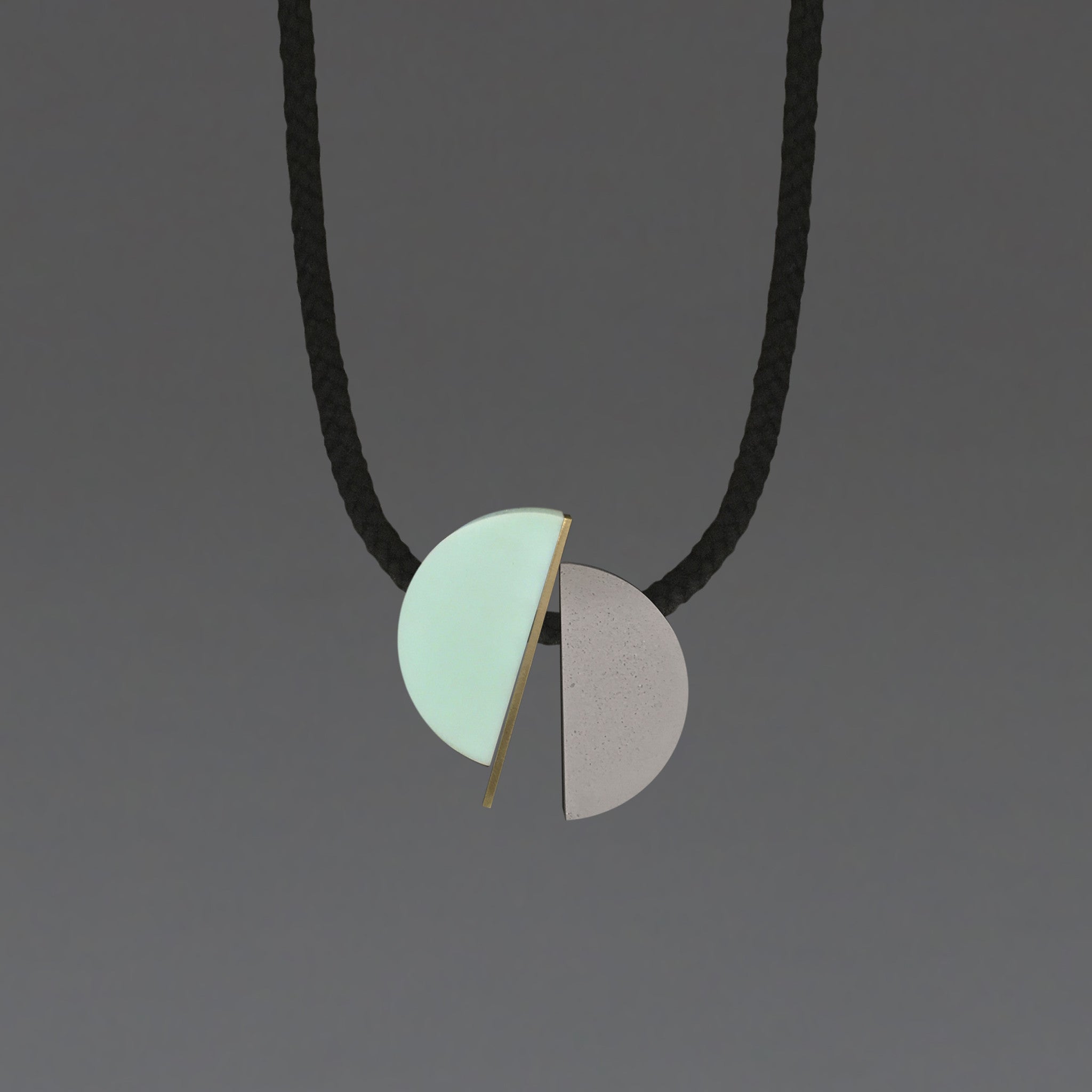 The Klee necklace is both elegant and fun. The three sections can move freely allowing the design to fall in different ways.  Klee is composed of our hand cast concrete-resin, a brass strip and a mint resin curve. A playful, contemporary design.