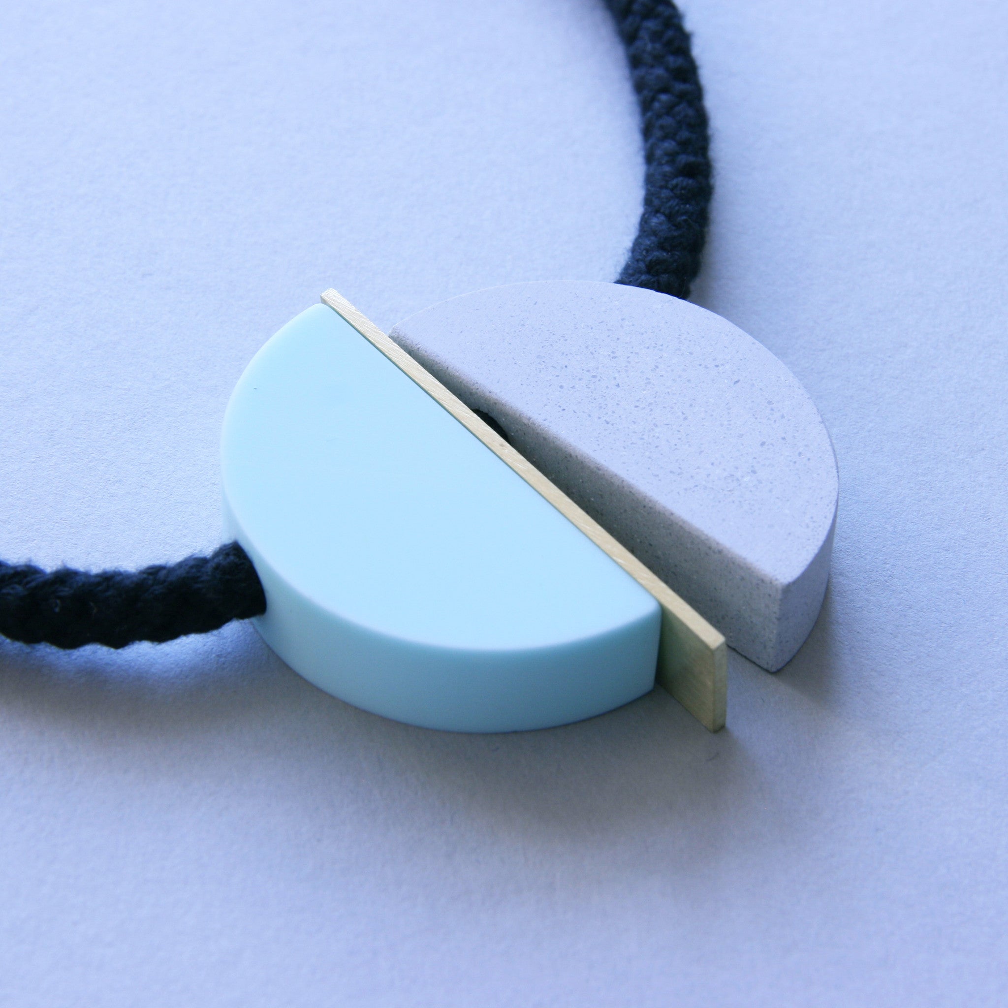 The Klee necklace is both elegant and fun. The three sections can move freely allowing the design to fall in different ways.  Klee is composed of our hand cast concrete-resin, a brass strip and a mint resin curve. A playful, contemporary design.