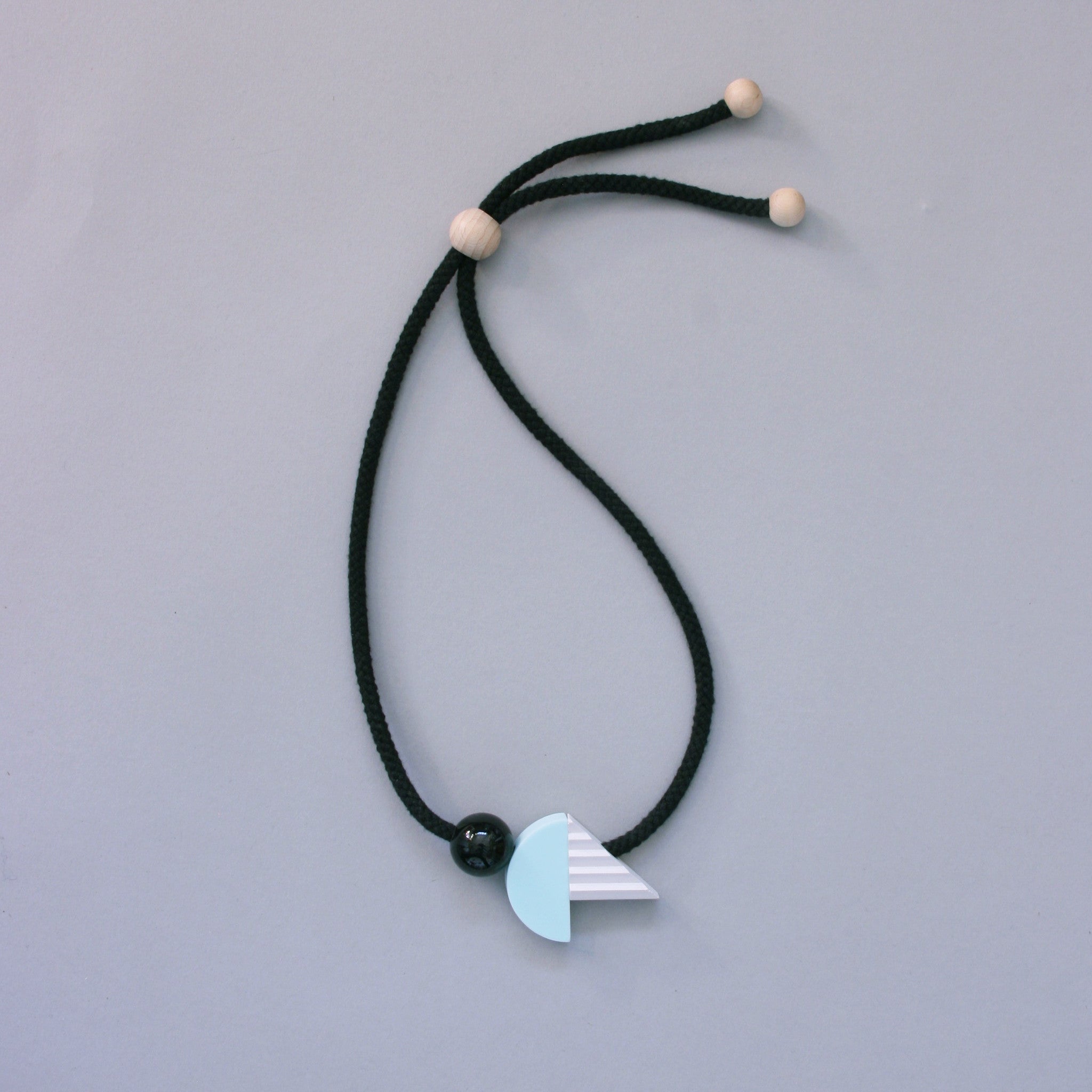 Striking geometric necklace composed of a mint resin curve and a hand cast ridged concrete-look resin triangle. The unusual mix of materials creates an intriguing necklace of varying textures and shapes.