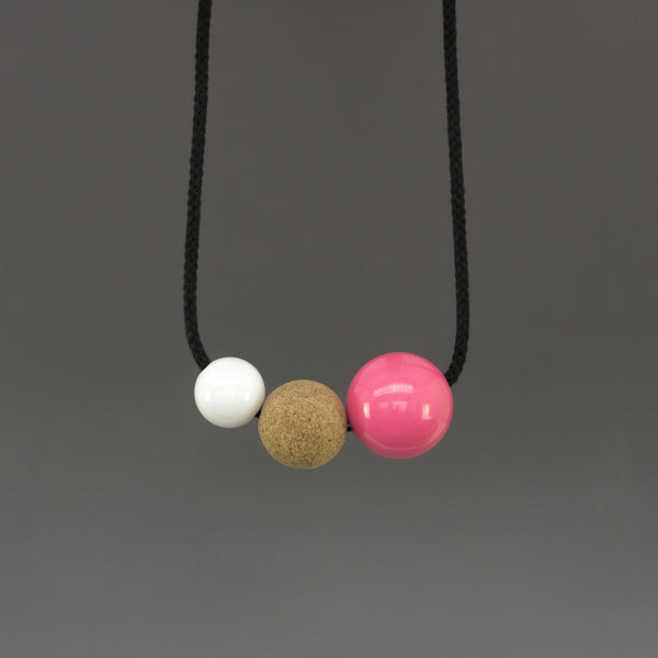 Bold, striking statement necklace composed of resin and cork balls on black cord. This design is a lovely mix of textures and materials and looks great on a simple top or dress.  Handmade in our London studio. Comes packaged in a branded kraft tube.