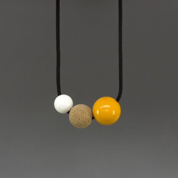 Bright and bold necklace composed of pink and white resin balls and cork on a black cord. Necklace can be worn either at neck or pendant length due to adjustable cord. Full drop is 45cm. This statement necklace looks great on a simple top. Handmade in our London studio.