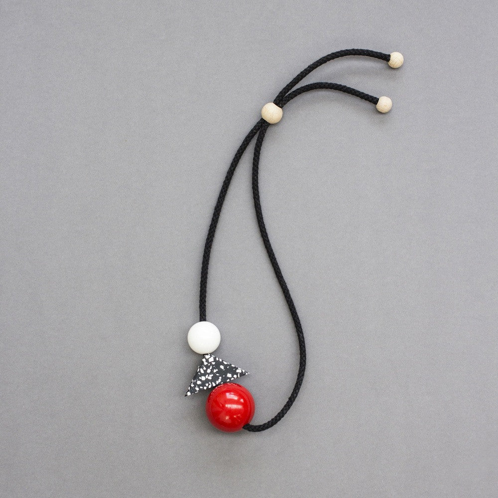 Teo is a bold and striking accessory, handmade in our London studio.  Composed of red and white resin balls with a black and white speckled jesmonite triangle.  A contemporary accessory with geometric shapes.