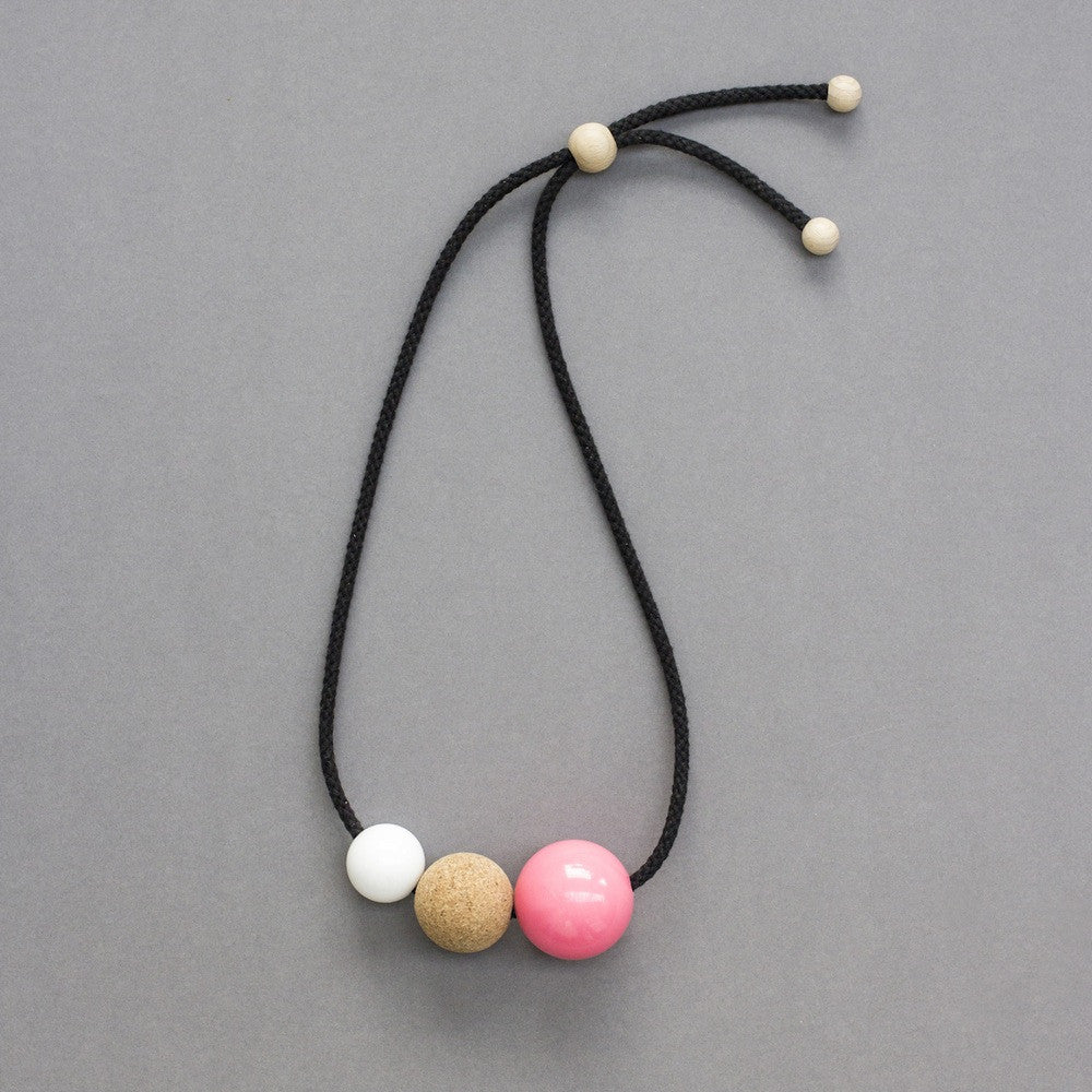 Bold, striking statement necklace composed of resin and cork balls on black cord. This design is a lovely mix of textures and materials and looks great on a simple top or dress.  Handmade in our London studio. Comes packaged in a branded kraft tube.