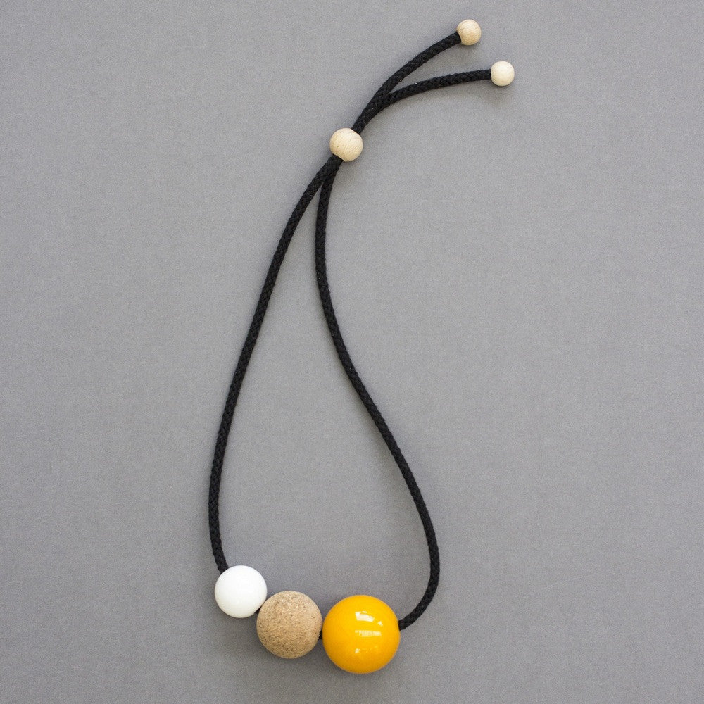 Bright and bold necklace composed of pink and white resin balls and cork on a black cord. Necklace can be worn either at neck or pendant length due to adjustable cord. Full drop is 45cm. This statement necklace looks great on a simple top. Handmade in our London studio.
