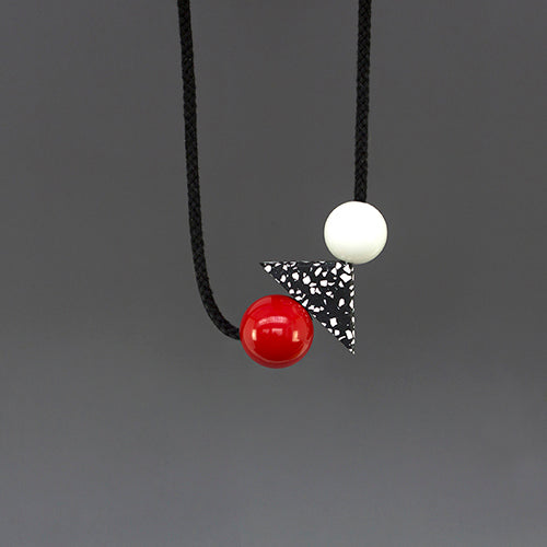 Teo is a bold and striking accessory, handmade in our London studio.  Composed of red and white resin balls with a black and white speckled jesmonite triangle.  A contemporary accessory with geometric shapes.