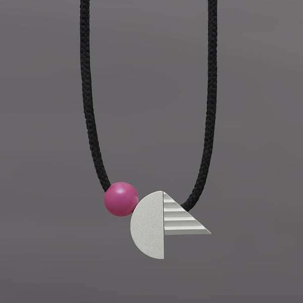The pop necklace is composed of 2 handcast shapes. A lovely concrete-effect curve measuring 50mm x 25mm which sits beside a cast ridged triangle which measures 30mm x 45mm. The bright pink ball (25mm) offers a pop of colour beside the understated concrete resin shapes.